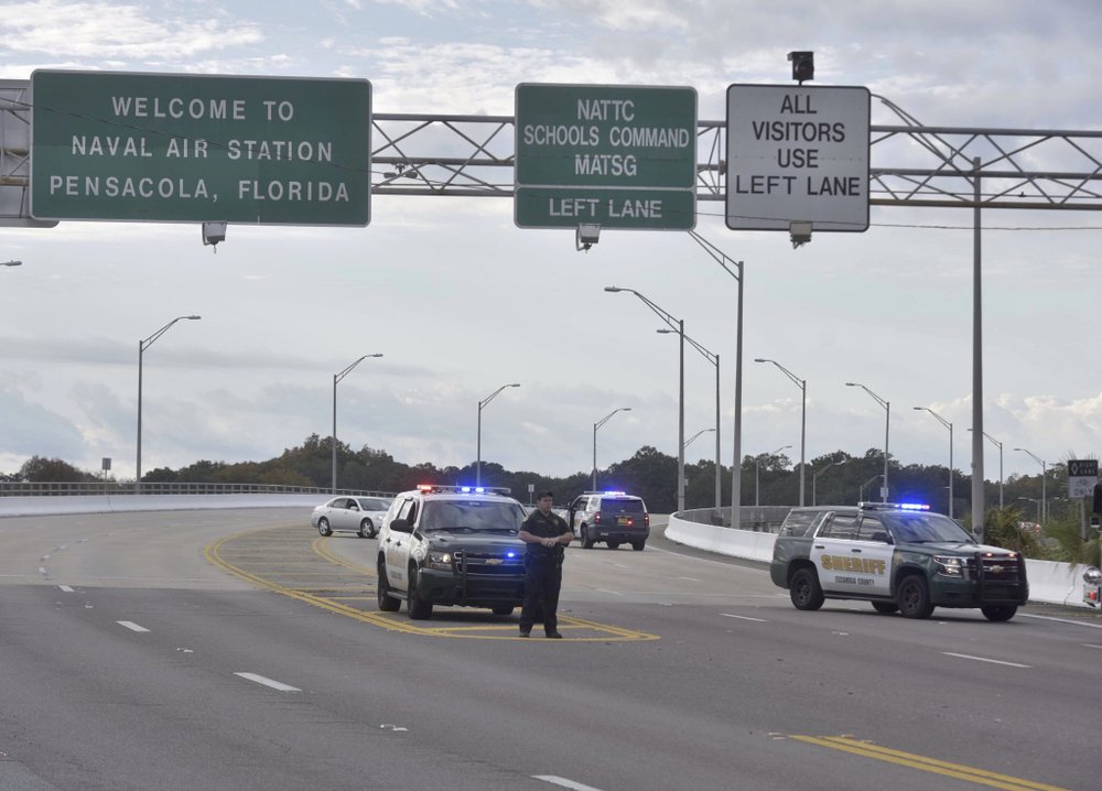 Police vehicles block the entrance to the Pensacola Air Base, Friday, Dec. 6, 2019 in Pensacola, Fla. The US Navy is confirming that a shooter is dead and several injured after gunfire at the Naval Air Station in Pensacola. (Tony Giberson/ Pensacola News Journal via AP)
